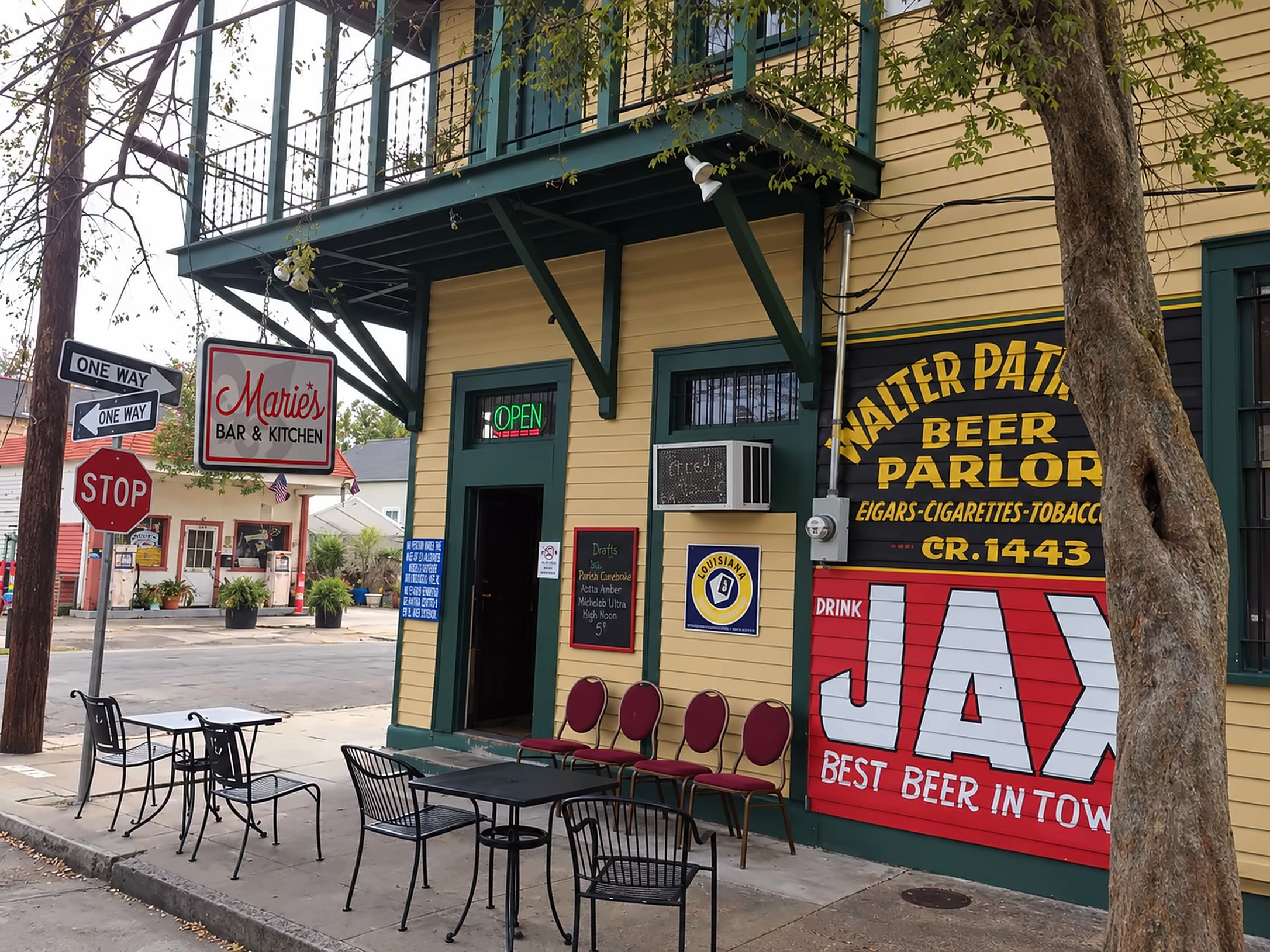 Marie's Bar on the corner of Burgundy and St. Roch: the hanging Marie's Bar & Kitchen sign, the green door, and the painted Walter Patrolia Beer Parlor and Drink JAX sign on the yellow wall.